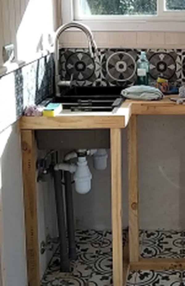 Lavaplatos de dos cámaras con las cañerías separadas a la vista debajo del mueble
